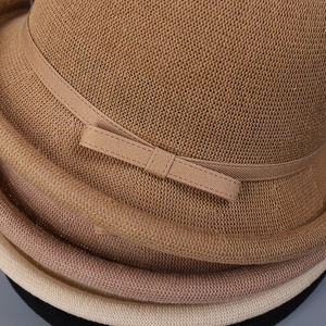 Close-up of stacked breathable knit sun hats with ribbon bows in brown and beige