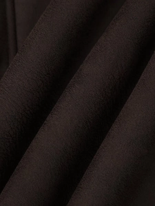 Detailed close-up of dark brown suede texture on a stylish women's winter jacket