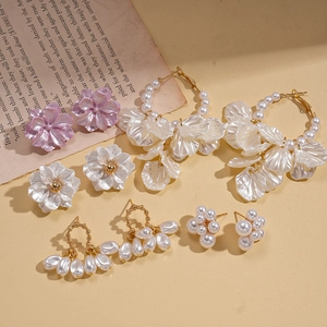 Détails des boucles d'oreilles fleurs et perles avec pétales violets et dorés