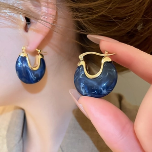 Gros plan de boucles d'oreilles vintage en résine marbrée bleue avec placage d'or