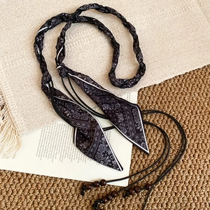 Détail d'une chaîne de taille bohème en tissu bandana noir avec perles en bois naturel