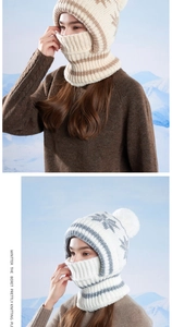 Detail of knitted winter balaclava with stripe snowflake patterns and plush pom-poms