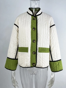 Close-up of cream quilted jacket with green contrast panels and black edge trim