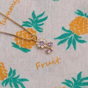 Collier fleur plaqué or avec zircon goutte violette sur une chaîne boîte élégante