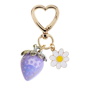 Close-up of cute purple strawberry and white daisy charms with a gold heart clasp