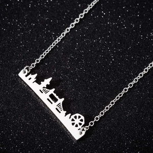 Detailed close-up of a silver skyline pendant featuring urban building silhouettes on glitter