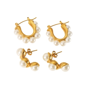 Close-up of vintage 18K gold stainless steel U-shaped hoops with elegant pearls