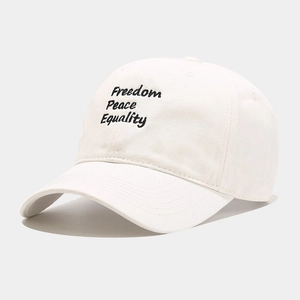 Close-up of cream baseball cap featuring triple letter embroidery and curved brim