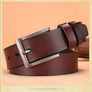 Macro shot of textured burgundy leather belt with gun-grey brushed metal buckle detail
