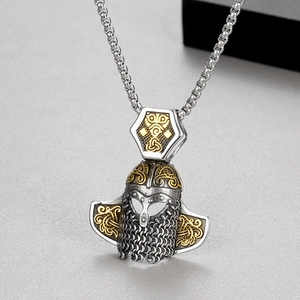 Détail macro d'un pendentif casque viking avec finition argentée et accents en relief doré