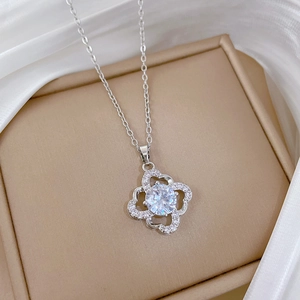 Detailed close-up of a silver clover pendant with sparkling crystals on a jewelry box