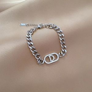 Détail du bracelet gourmette en acier titane argenté avec un pendentif ovale lettre D