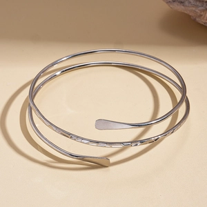 Detail of silver double-layered spiral cuff bracelet featuring a textured hammered finish