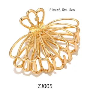 Detail of a gold alloy metal butterfly hair claw clip, 6.5x4.5cm size with polished finish