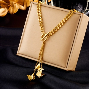 Detail of gold multilayer chain with T-bar clasp and butterfly pendants on jewelry box