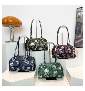 Artistic display of floral skull print shoulder bags in four colors on geometric stands
