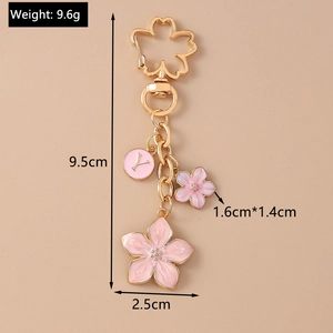 Detailed view of pink cherry blossom keychain with gold-tone letter Y charm and measurements