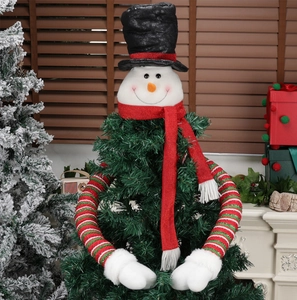 Detailed view of snowman Christmas tree topper with red scarf and long huggable arms