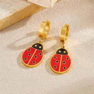 Golden hoop earrings with red ladybug pendants featuring black spots and polished finish