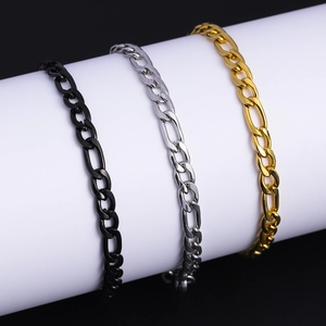 Three-color Figaro chain bracelets in black, silver and gold on a white stand