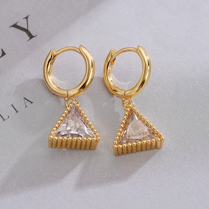 Minimalist gold plated triangle earrings with sparkling cubic zirconia on textured background