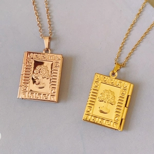 Detail of vintage book-shaped pendant with 18K gold and rose gold finish over titanium steel