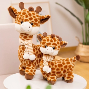 Cute giraffe plush toy set with orange striped scarves on a minimalist white table