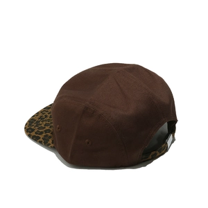 Detail view of the leopard print brim and adjustable metal buckle on brown camper cap