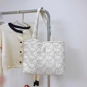 Quilted off-white shoulder bag with rabbit embroidery and matching knit cardigan