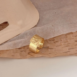 Macro shot of S925 sterling silver gold-plated ring with irregular hammered texture