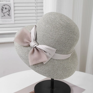 Detailed view of the fine woven texture and elegant double layered bow on a grey straw hat
