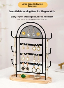 Detail view of black iron jewelry organizer with wooden base for earrings and necklaces