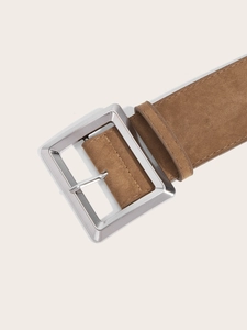 Détail d'une ceinture marron en daim avec boucle argentée carrée et surpiqûres fines