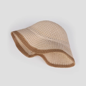 Dettaglio del cappello da sole in paglia bicolore con trama traspirante e tesa pieghevole