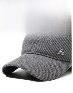 Detailed close-up of dark gray twill winter baseball cap with metallic logo and sturdy brim