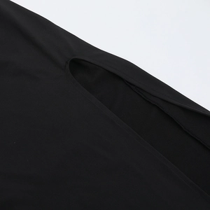Gros plan d'une robe noire asymétrique montrant le détail découpé et la couture soignée