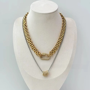 Detail of 18K gold braided chain with rhinestone carabiner and layered silver necklace