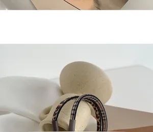 Close-up of leopard and plaid pattern hairbands with leather buckle on ceramic decor