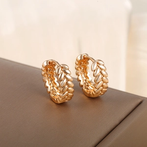 Golden round huggie earrings with geometric wheat leaf engraving on a leather base