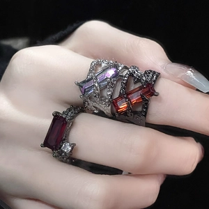 Macro shot of punk style rectangle gemstone rings with dark rocky metal texture