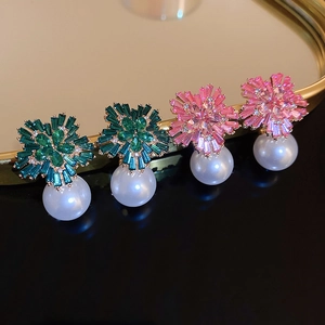 Macro shot of floral earrings with sparkling cubic zirconia and white hanging pearls
