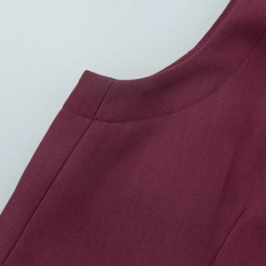 Macro detail of wine red vest showing premium twill fabric texture and fine stitching