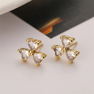 Macro shot of 18k gold plated clover stud earrings with sparkling clear zircon heart details