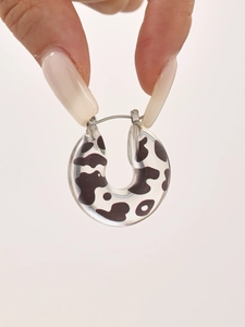 Close-up of U-shaped cow print resin earrings with metal clasp detail for women