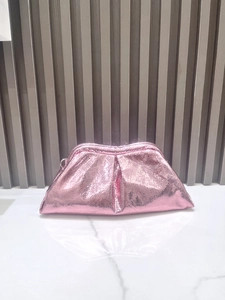 Detail shot of pink snake texture cloud clutch with metallic buckle on marble surface