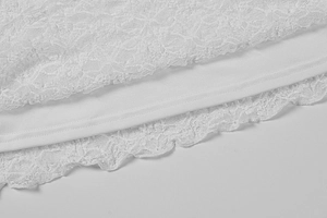 Détail de l'ourlet en dentelle florale blanche avec doublure pour cette robe élégante