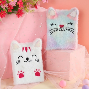 Detail of plush cat journals in white and rainbow colors with soft embroidery texture