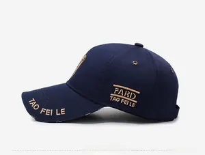 Détail d'une casquette bleu marine avec broderie dorée et œillets métalliques sur le côté