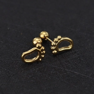 Detailed view of tiny gold baby feet stud earrings with screw ball back closure