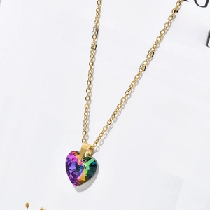 Detail shot of golden heart-shaped necklace with vibrant rainbow zircon pendant